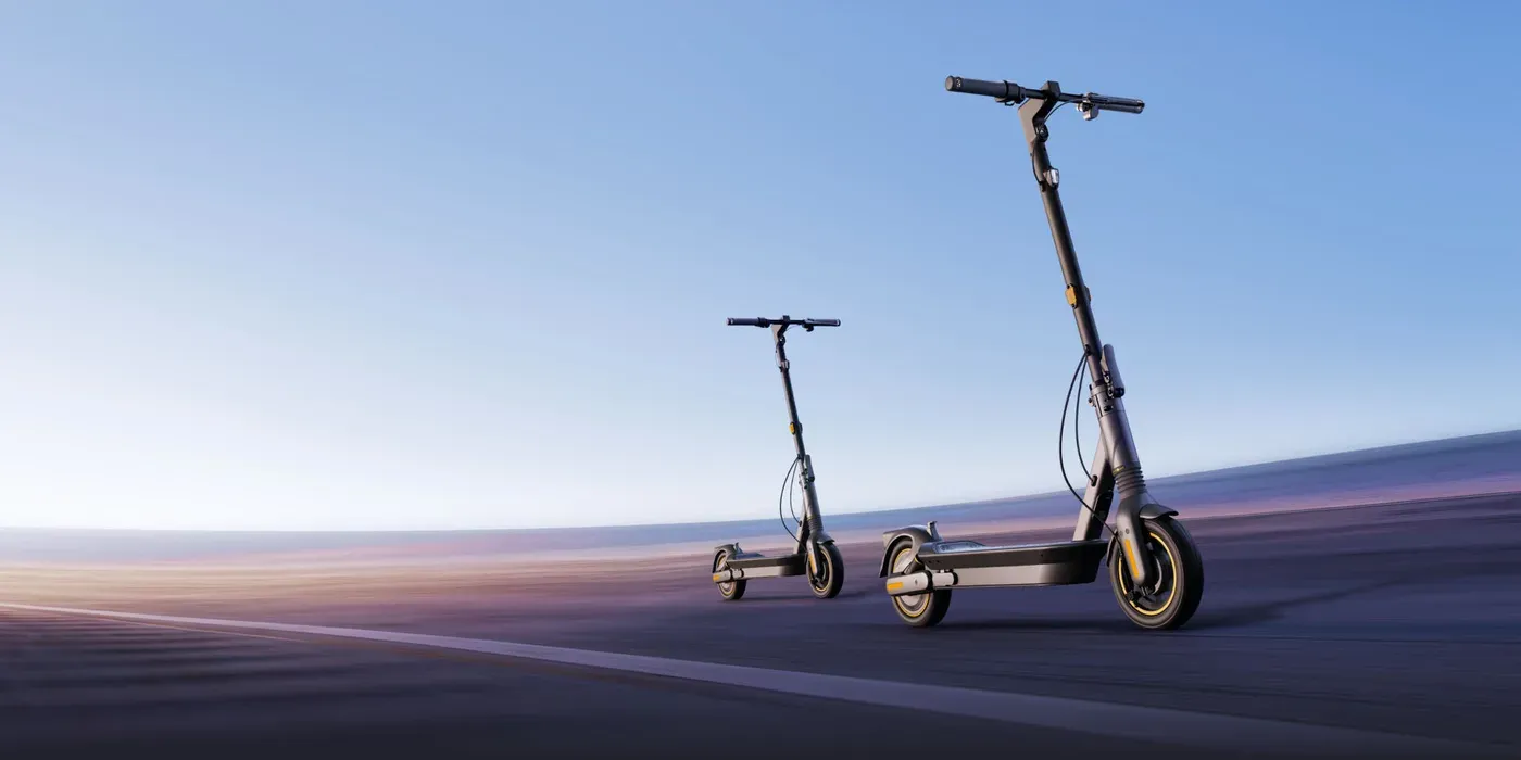 Deux trottinettes Ninebot MAX G2 E dépliées sur une route, sous un ciel bleu